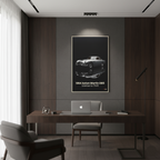 Modern office interior with a desk, chair, and framed Aston Martin DB5 poster on the wall.